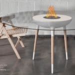 table and chairs around a glass table with a small firepit in the center.