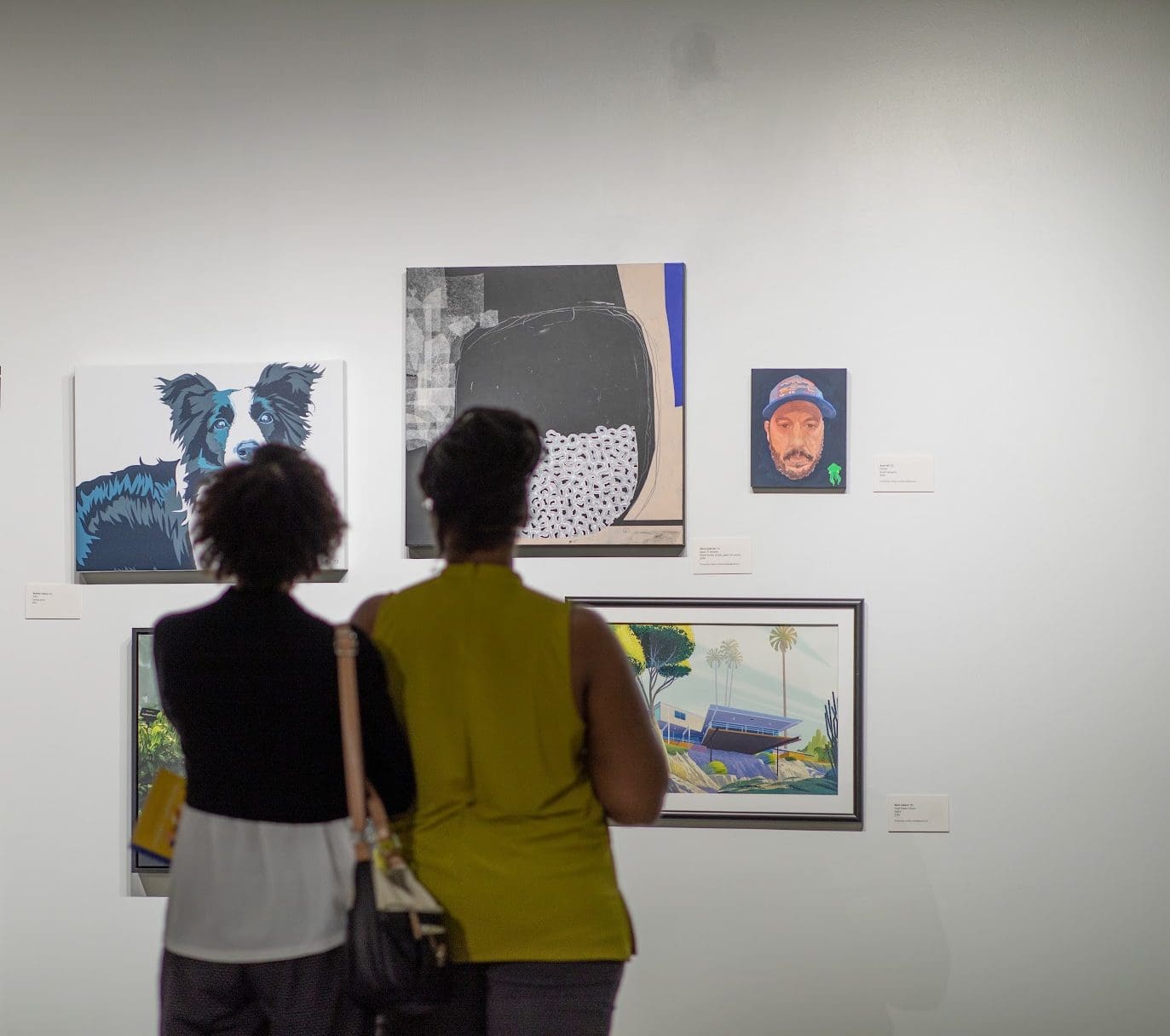 Two students looking at artwork in a gallery.