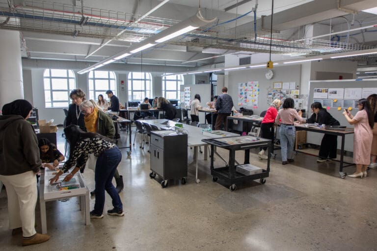 A group of BFA Interior Design and MA and MFA Color & Materials Design students work collaboratively in an Interior Design studio.