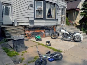 light grey shingled house with a motorcycle out front