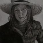 a young girl in a straw hat and puffy jacket